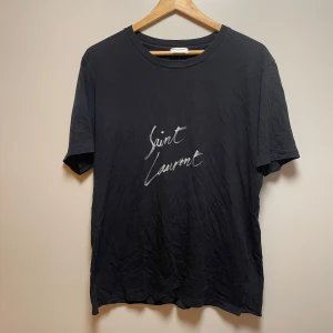 Saint Laurent T-shirt  - Svart saint Laurent T-shirt med tryck, nypris runt 5-6 tusen kronor. Säljer för 1,500kr. Storlek S passar M
