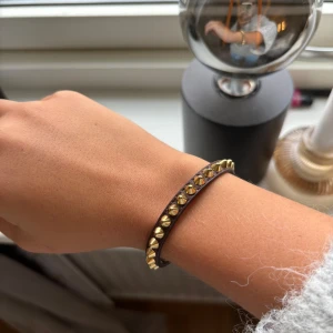 Guldigt armband med nitar - Snyggt och trendigt armband i guld med nitar. Armbandet är smalt och passar bra till både vardag och fest. Det kommer inte till användning längre och säljer därmed vidare.