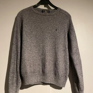 Stickad Morris Tröja - Säljer en klassisk grå stickad tröja från Morris Den har en liten broderad logga på bröstet och ribbade muddar vid ärmslut och nederkant. Perfekt för kyliga dagar! Tar också emot byten Skick 8/10