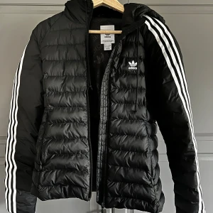 Adidas jacka - Svart höst/vinter jacka från Adidas i storlek Small. Jättefint skick, riktigt bekväm och inget slitage förutom ett litet litet hål på ena armen som knappt syns. Har mest hängt i garderoben det senaste året pga att jag skaffat annan jacka. Dam modell 