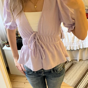 Kortärmad blus Gina tricot - Gullig lila blus från Gina Tricot. Snörning i midjan. Väldigt fint skick💕 