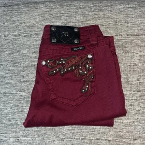 Vinröda jeans från Miss Me - Snygga vinröda jeans från Miss Me i nytt skick. Original pris är 1800kr, pris lappen sitter fortfarande på. Passar både till vardags och fest!