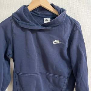 Säljer en blå Nike huvtröja / hoodie i storlek 158. Plagget har fickor samt en luva. Den är Köpt ifrån Nike & är äkta.