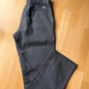 874 Work Pants från Dickies. Byxa i lös passform med hög midja i snygg vintage-stil. Lediga byxor med raka ben med pressveck. Slitstarkt tyg i twillblandning. Nypris 750:- Lite uppruggat på tyget nedanför fickor av skateboard. Längd innerben 80 cm.