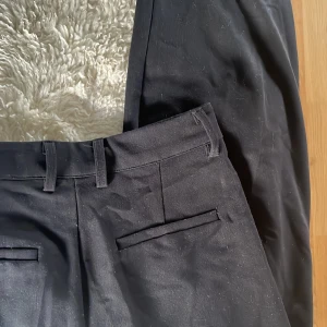 Svarta kostymbyxor från BikBok - Säljer ett par stilrena svarta kostymbyxor från BikBok i storlek 38. Byxorna har en klassisk design med raka ben och diskreta fickor. Knappt använda då de är för stora!
