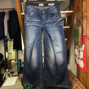 Dark Blue Baggy Flared Jeans - Säljer mina handgjorda baggy flared jeans. Storlek 32/32. Mått i midjan är 40cm, längd är 107cm och benöppningen är 33,5cm. Riktigt snygg passform! 183cm lång på bild 3 & 4. Hör gärna av dig om du undrar något mer!
