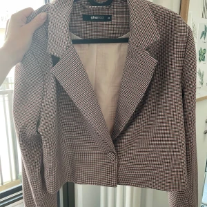 Rutig kavaj från Gina Tricot - Säljer en snygg rutig kavaj från Gina Tricot. Den är i en kortare modell och långa ärmar. Perfekt för både vardag och fest!
