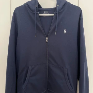 Zip-hoodie Ralph Lauren - Säljer en snygg mörkblå zip-hoodie från Ralph Lauren. Perfekt för vår/höst. Köpt på Zalando för 1 999kr, säljer för 800kr. Tröjan är i mycket bra skick, väldigt sparsamt använd!!💯
