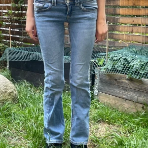 Ljusblå bootcut jeans - Säljer ett par snygga ljusblå bootcut jeans. De är lågmidjade och har en klassisk femficksdesign med knappar och dragkedja fram!❤️