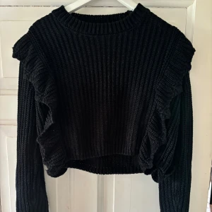 Stickad tröja  - Stickad tröja med lite volangerna fram till. Bra skick.