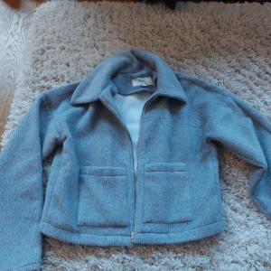 Grå jacka från VILA - Säljer en snygg grå jacka från VILA i storlek 34 (EU). Jackan har en dragkedja framtill och två fickor. Den är perfekt för höst och vår, och ger en stilren look med sin enkla design. Materialet känns mjukt och bekvämt, vilket gör den skön att bära till vardags. Använd ett fårtal gånger, inga defekter. Är kallare grå färg💞 Kontakta för fler frågor