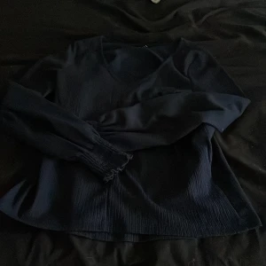 Mörkblå tröja från Vero Moda - Säljer en snygg mörkblå tröja från Vero Moda. Den har en v-ringad hals och långa ärmar med en ribbad struktur. Perfekt för både vardag och lite finare tillfällen. Tröjan är i nästan nyskick, använd något enstaka tillfälle 💕💕på vissa bilder ser den väldigt blå ut men det var pågrund av blixten! 