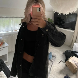 Svart jeansjacka - Säljer en svart jeansjacka i overzise passform. Den har knappar framtill och är perfekt för en casual look. Jackan är långärmad och passar bra till både vardag och fest.🌸🌸storleken är xxs men är mer som en M beroende på hur man vill att den sitter.