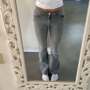 Grå jeans bootcut/utsvängda (mid-waist?) - Grå utsvängda jeans från Gina Tricot i storlek 36, väldigt bra skick, skulle säga att de är mer mid-waist än lågmidjade men tror det ser olika ut beroende på vem som har på dem