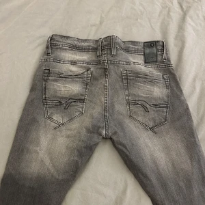 Gråa Jeans - Snygga grå jeans med en klassisk femficksdesign. De har en normal passform och är tillverkade i ett slitstarkt denimtyg. Perfekta för en avslappnad stil.