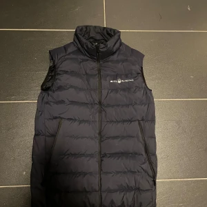 Sail racing väst - Snygg mörkblå  dunväst från Sail Racingi storlek 160 men kan även passa 170  i mycket bra skick. Perfekt för höst och vår.