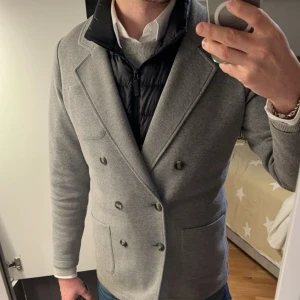 Grå kavaj från John Henric - Säljer en stilren grå kavaj/kappa  från John Henric i storlek M. Den har dubbelknäppning och riktigt fet. Den är i mycket bra skick och passar utmärkt för både vardag och fest. Skön och snygg, ett måste i garderoben! 🕴️hör av dig vid minsta lilla fråga!!!