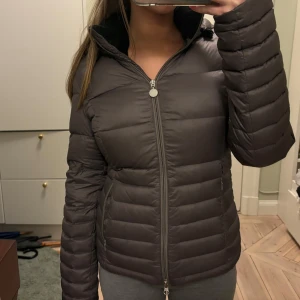 EA7 dunjacka  - Säljer den här super fina dunjackan i en grå lila färg från Armani, i storlek S. Jackan är i bra kvalitet men har defekter vid ena jackfickan där stygnen gått upp lite och har en lite fläck på ena ärmen. Säljs för att den inte kommer till användning längre. 