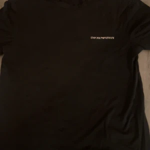 Svart t-shirt från Emporio Armani - Snygg svart t-shirt från Emporio Armani med logotyp på bröstet. Köpt för 6 månader sen ungefär och säljer pga storleken. Storleken är S och tröjan är i bra skick. 