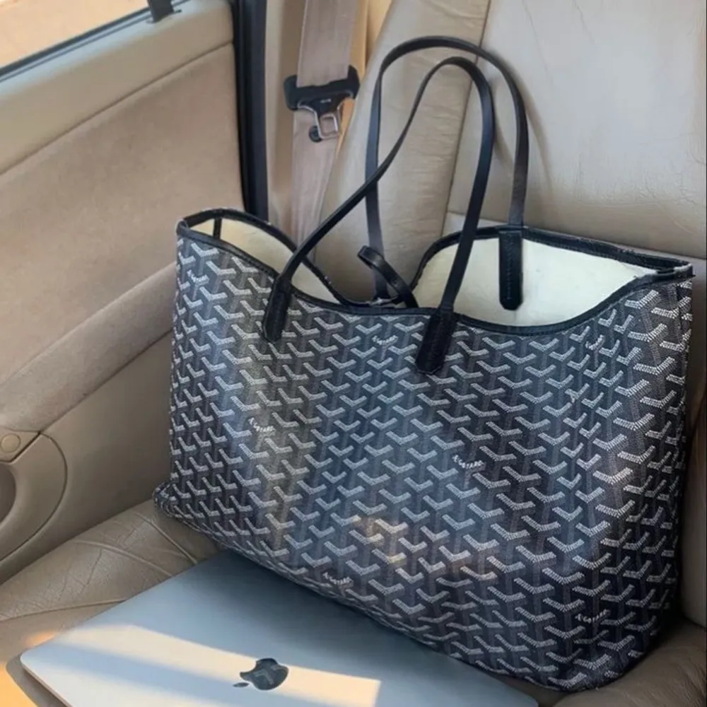 Stilren shoppingväska i svart och vitt med ett geometriskt mönster. Väskan har långa handtag och är rymlig, perfekt för att bära med sig allt man behöver under dagen.. Laukut & Käsilaukut.