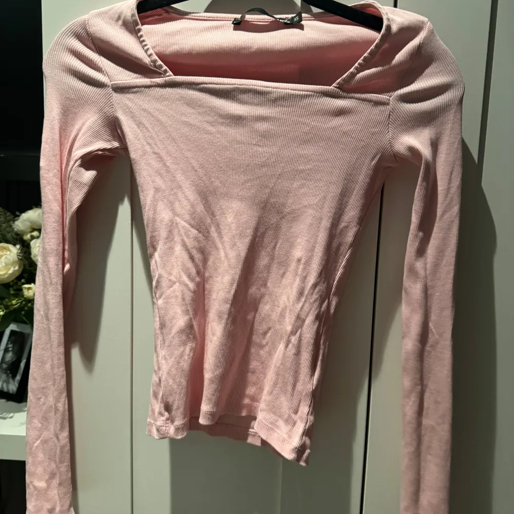 Säljer en söt rosa ribbad topp med långa ärmar. Perfekt för både vardag och fest. Toppen har en enkel och stilren design som gör den lätt att matcha med olika outfits.. Toppar.