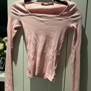Rosa ribbad topp - Säljer en söt rosa ribbad topp med långa ärmar. Perfekt för både vardag och fest. Toppen har en enkel och stilren design som gör den lätt att matcha med olika outfits.