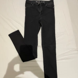 Svarta jeansbyxor - Snygga svarta jeansbyxor i slim fit med dragkedja och knapp framtill. Perfekta för en stilren look. Har skönt stretchigt material.