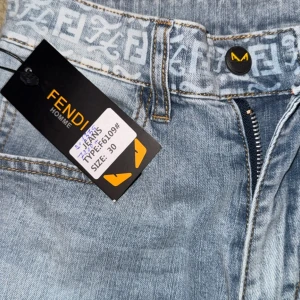 Blå jeans från Fendi - Snygga blå jeans från Fendi med ett unikt mönster på bakfickan. De har en klassisk femficksdesign och dragkedja. Perfekta för en stilren look.