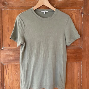 Olivgrön t-shirt från Dagmar - Säljer en stilren olivgrön t-shirt från Dagmar i storlek S. Den är i mycket bra skick och perfekt för vardagsbruk. T-shirten är kortärmad och gjord i ett mjukt bomullsmaterial. Passar perfekt till både jeans och kjol!
