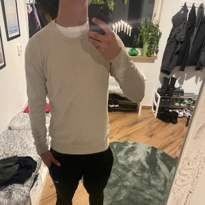 Beige tröja från Jack and Jones  - Säljer en stilren beige långärmad tröja från Jack and Jones. Ett håll vid armhålan men går enkelt att sy igen. Storlek M.