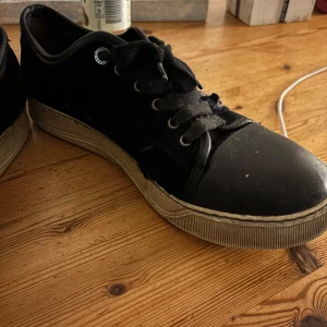 Svarta sneakers i mocka - Säljer ett dessa lanvin skor i mocka med snörning. De har en robust sula och är i okej skick, perfekta för vardagsbruk. Passar till både jeans och mer avslappnade outfits. Storlek 41-42. 