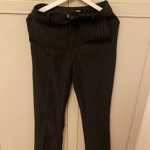 Svarta kostymbyxor med vita ränder - Snygga svarta kostymbyxor från bikbok med vita ränder. Sitter så snyggt på!!🐆❤️‍🔥