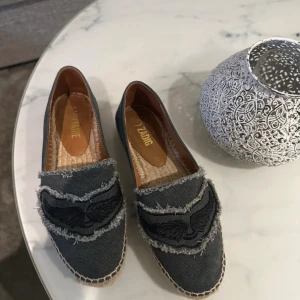 Grå loafers från Zadig & Voltaire - Snygga grå loafers från Zadig & Voltaire med fransiga detaljer och broderad design. Köpte i somras på deras egna hemsida, knappt använda köptes för runt 3000kr  Super bra skick 