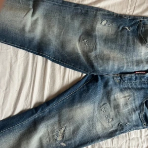 Blå jeans från Dsquared2 - Snygga blå jeans från Dsquared2 med slitna detaljer och en klassisk femficksdesign. Jeansen är i väldigt bra skick! Ny pris 4500 står storlek 48 vilket är ungefär 32/32 😃sitter slim