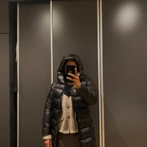 Colmar Original Dunjacka - LADIES JACKETS - Dunkappa / -rock i färgen nero (svart) i storlek 38. Jackan köptes 2022 och har använts sparsamt, i mycket bra skick. Passformen går in lite mer i midjan, vilket ger jackan en timglasformad silhuett. Nypris 5995 kr, mitt pris 3000 kr. Säljs eftersom jag har andra vinterjackor som används mer. En stilren och funktionell jacka som håller värmen under kalla vinterdagar. Snygg och varm svart dunjacka med huva. Jackan har en lång passform och stängs med dragkedja. 