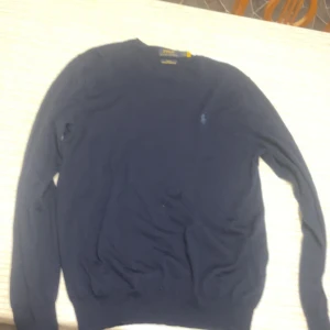 Mörkblå tröja från Polo Ralph Lauren - Snygg mörkblå tröja från Polo Ralph Lauren med rund hals och broderad logga på bröstet. Perfekt för en stilren look.Ordinare pris 2300 inte använd så mycket. OBS! Pris kan diskuteras 