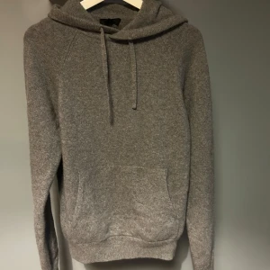 Cashemre Hoodie COS - Säljer en stilren grå hoodie från COS i cashemre. Storlek S men skulle påstå att den även passar er med storlek M. Använd bara ett handfull gånger så därav skick 10/10. Nypris på denna ligger på 2500 och säljer nu för 1299
