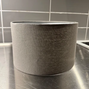 Grå lampskärm i tyg - Snygg och stilren grå lampskärm i tyg. Perfekt för att ge ditt rum en modern touch. Enkel att montera och passar de flesta lampfötter.