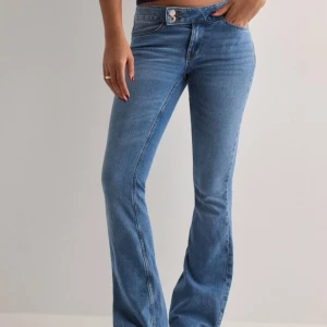Blå bootcut jeans - Snygga blå bootcut jeans med låg midja. Perfekta för en avslappnad stil med en klassisk touch. De har en knapp och dragkedja framtill samt fickor både fram och bak. Helt oanvända då dom var försmå! 