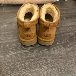 Bruna UGG boots - Säljer ett par klassiska bruna UGG boots i mocka med mjukt foder. Perfekta för kalla dagar med sin varma och bekväma insida. Slitna därav priset vill gärna bli av med d utan att behöva slänga! 