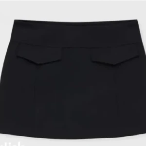 Svart kortkjol med fickdetaljer - Snygg svart kortkjol från zara med stilrena fickdetaljer framtill.  