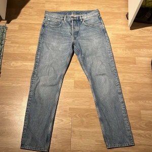 Blå jeans från arket  - Säljer ett par klassiska blå jeansbyxor i bra skick. De har en regular passform och är tillverkade i jeansmaterial. Perfekta för vardagsbruk och kan matchas med det mesta i garderoben. Passar lika bra med en vardaglig hoodie och sneakers som en skjorta eller varför inte en merino tröja och finare boots. Passar både höst och vår.