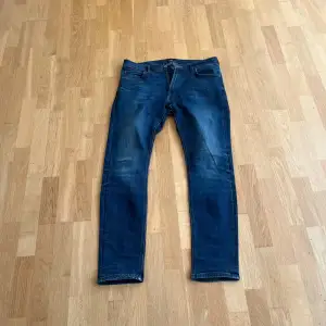 Säljer ett par snygga mörkblå jeans i bra skick. De har en klassisk femficksdesign och en normal passform. Perfekta för både vardag och fest! 🕺