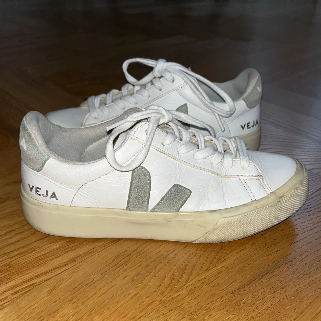 Vita sneakers med ljusgröna detaljer från Veja