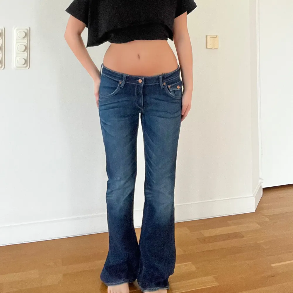 Snygga blå bootcut jeans med låg midja och klassisk femficksdesign. Perfekta för en avslappnad stil med en touch av retro. Passar bra till både sneakers och klackar.. Jeans & Byxor.