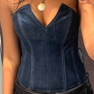 Mörkblå jeanskorsett - Snygg mörkblå jeanskorsett i tight passform. Den är axelbandslös och har en djup v-ringning som ger en stilren look. Perfekt för en utekväll eller fest! 💙 Från Zara, storlek S.