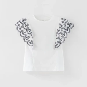 Vit topp med spetsdetaljer - Superfin vit topp från Zara med spetsdetaljer på ärmarna. Säljer pga att den tyvärr aldrig kommit till användning, prislappen är kvar. Storleken funkar för dem som har S. Köparen står för frakt.