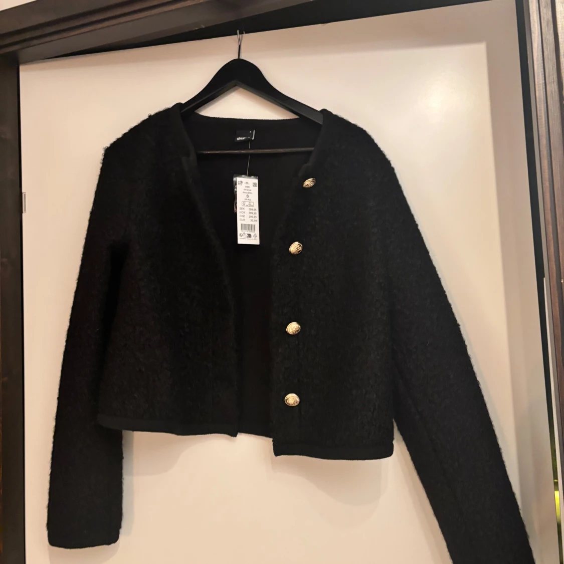 Svart kofta med guldknappar 