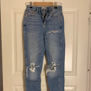 Blå slitna jeans  - Säljer ett par blå slitna jeans från lager 157 med hög midja.