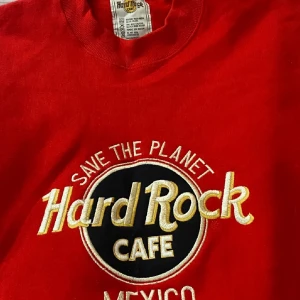 Röd tröja från Hard Rock Cafe - Säljer en cool röd tröja från Hard Rock Cafe med texten 'Save the Planet' och 'Mexico' broderat på framsidan. Perfekt för en avslappnad stil och att visa lite attityd. Tröjan är i bra skick och passar perfekt för höst och vår.